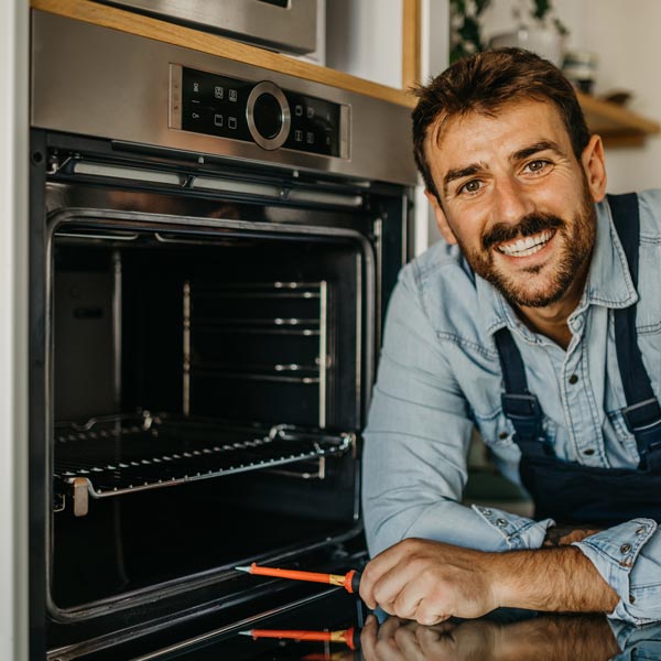 repair technician in front of oven