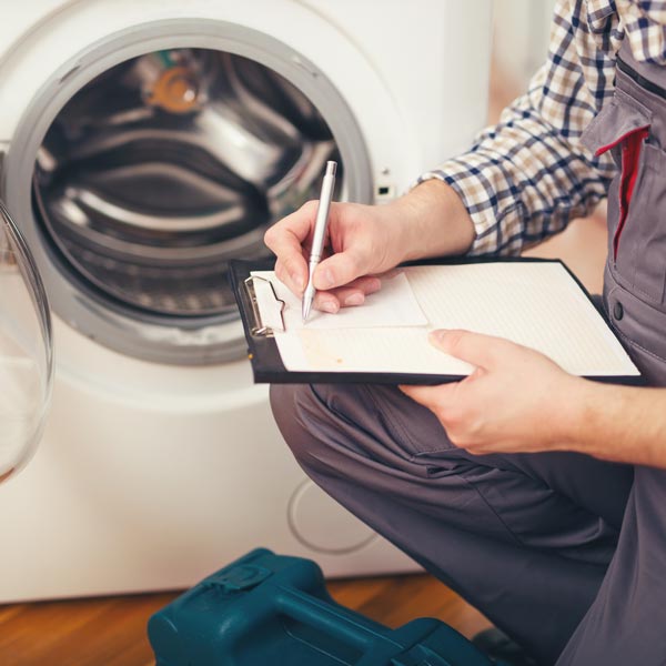 man with clipboard in front of washing machine