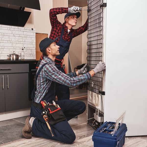 Expert repairing a refrigerator at Aaron's Home Appliance Repair in Salt Lake County, UT