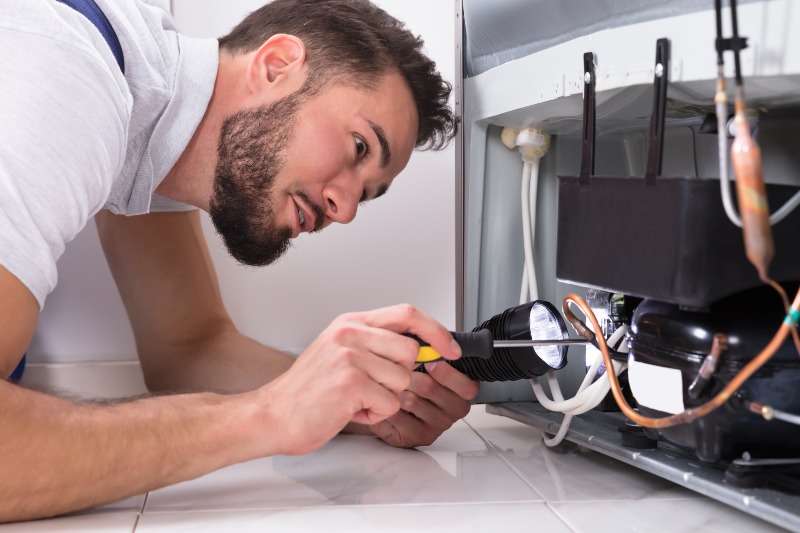 Man repairing refrigerator ice maker in Salt Lake City, UT