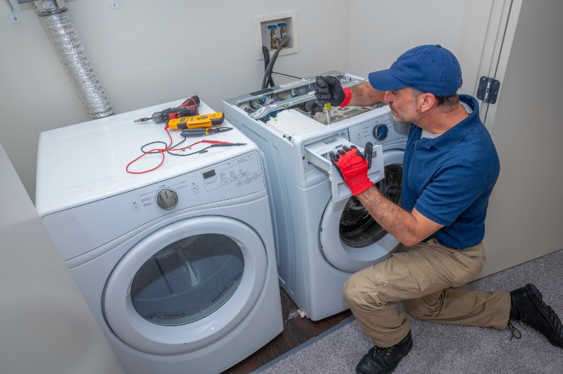 Appliance technician working on a front load washing machine in Salt Lake City, UT